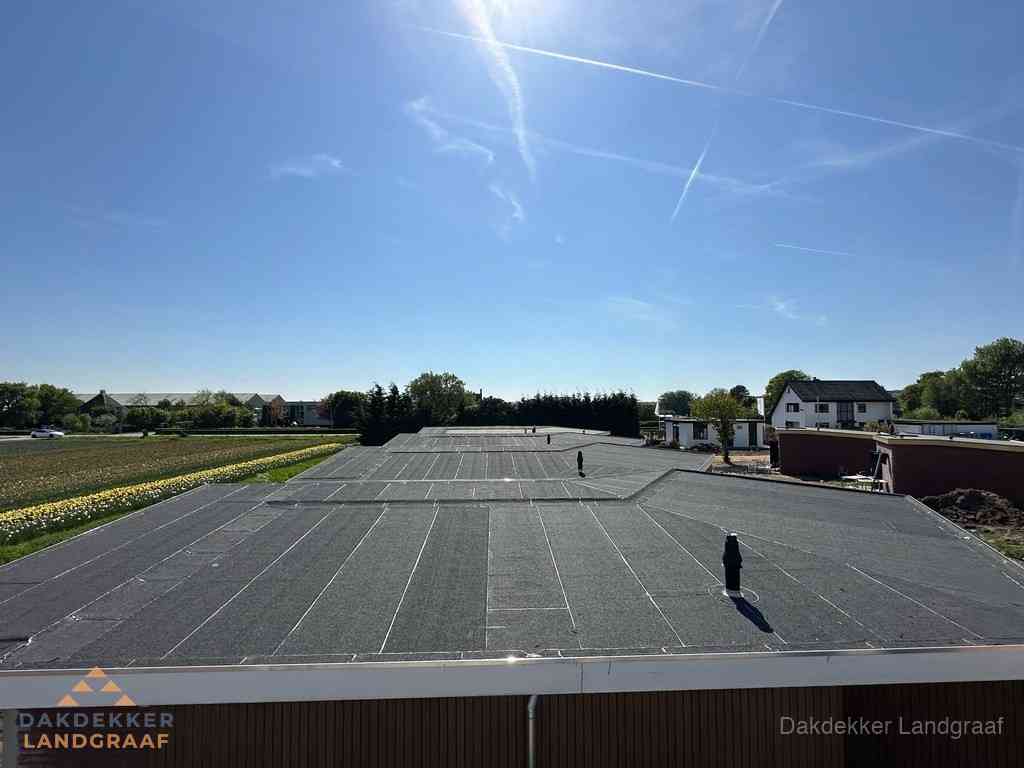 Groot plat dak met bitumen dakbedekking op bedrijfspand in Landgraaf Groot plat dak met bitumen dakbedekking op bedrijfspand in Landgraaf
