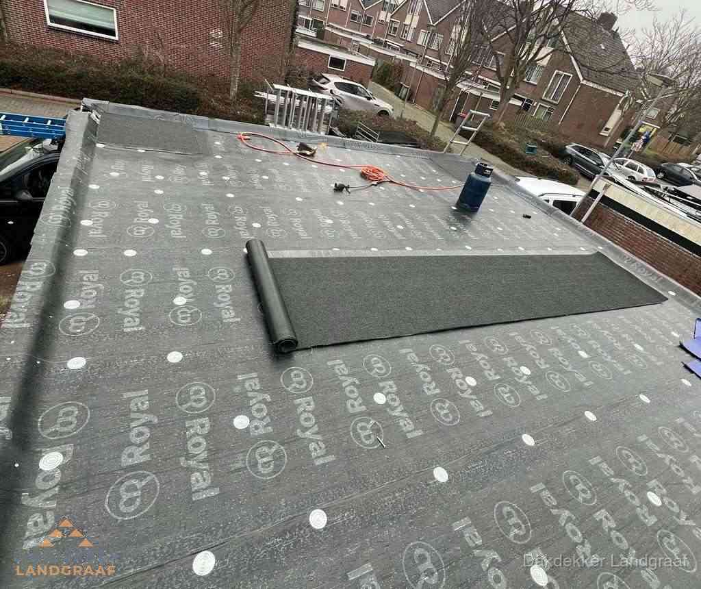 Dakdekker aan het werk met gasbrander op plat bitumen dak in Landgraaf Dakdekker aan het werk met gasbrander op plat bitumen dak in Landgraaf